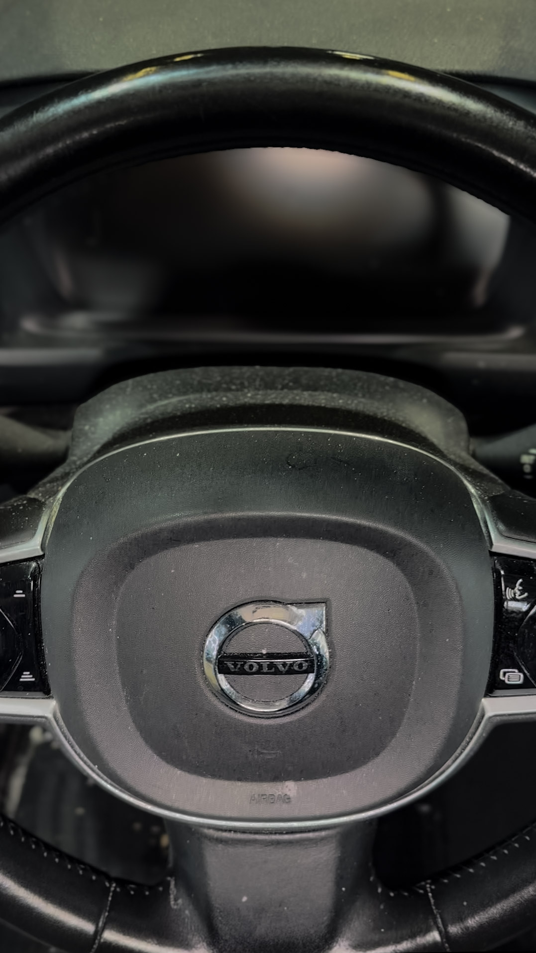Dusty Volvo leather steering wheel with built-up grime on the hub and controls before professional interior detailing by High Shine Detailing in Shakopee MN