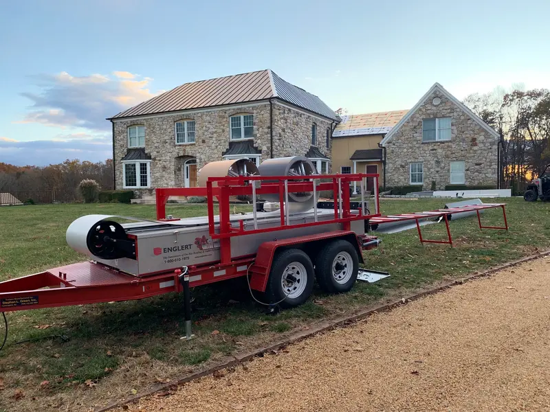 Completed standing seam metal roof on a stone home