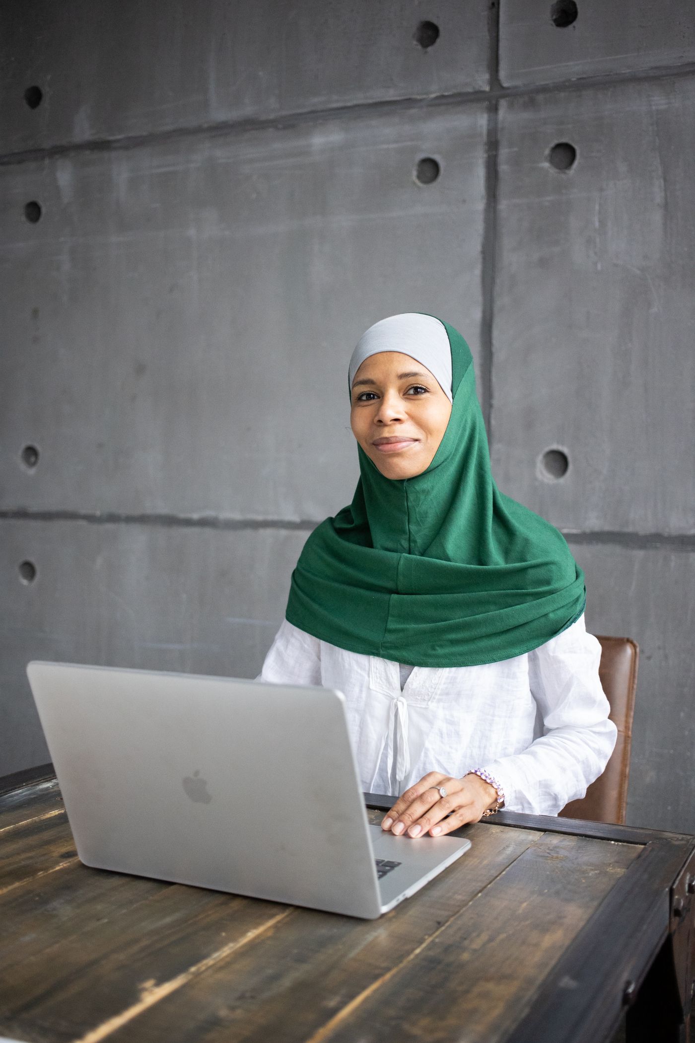 Newcomer to Canada smiling while working on her tax return at a laptop