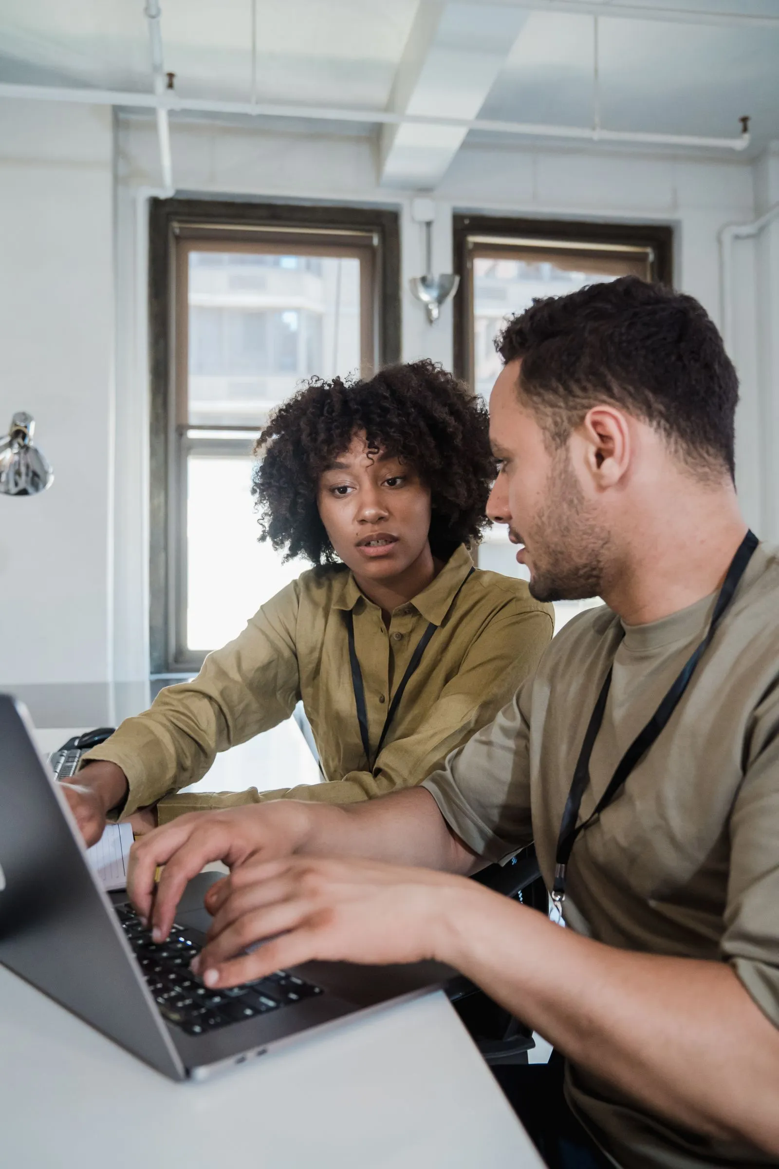 Two small business teammates reviewing payroll on a laptop
