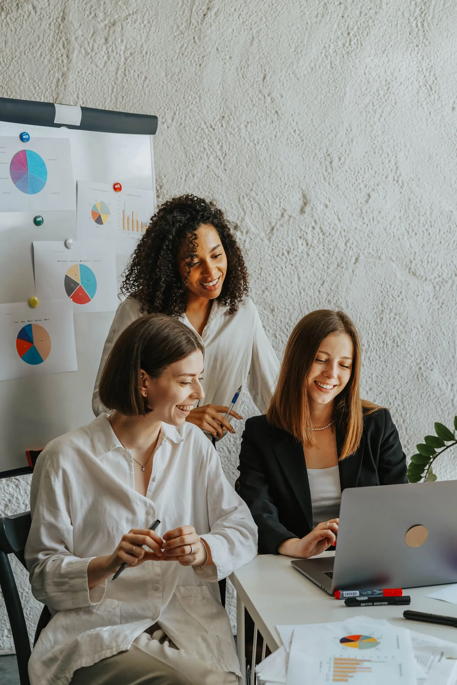 Small business colleagues reviewing payroll together on a laptop