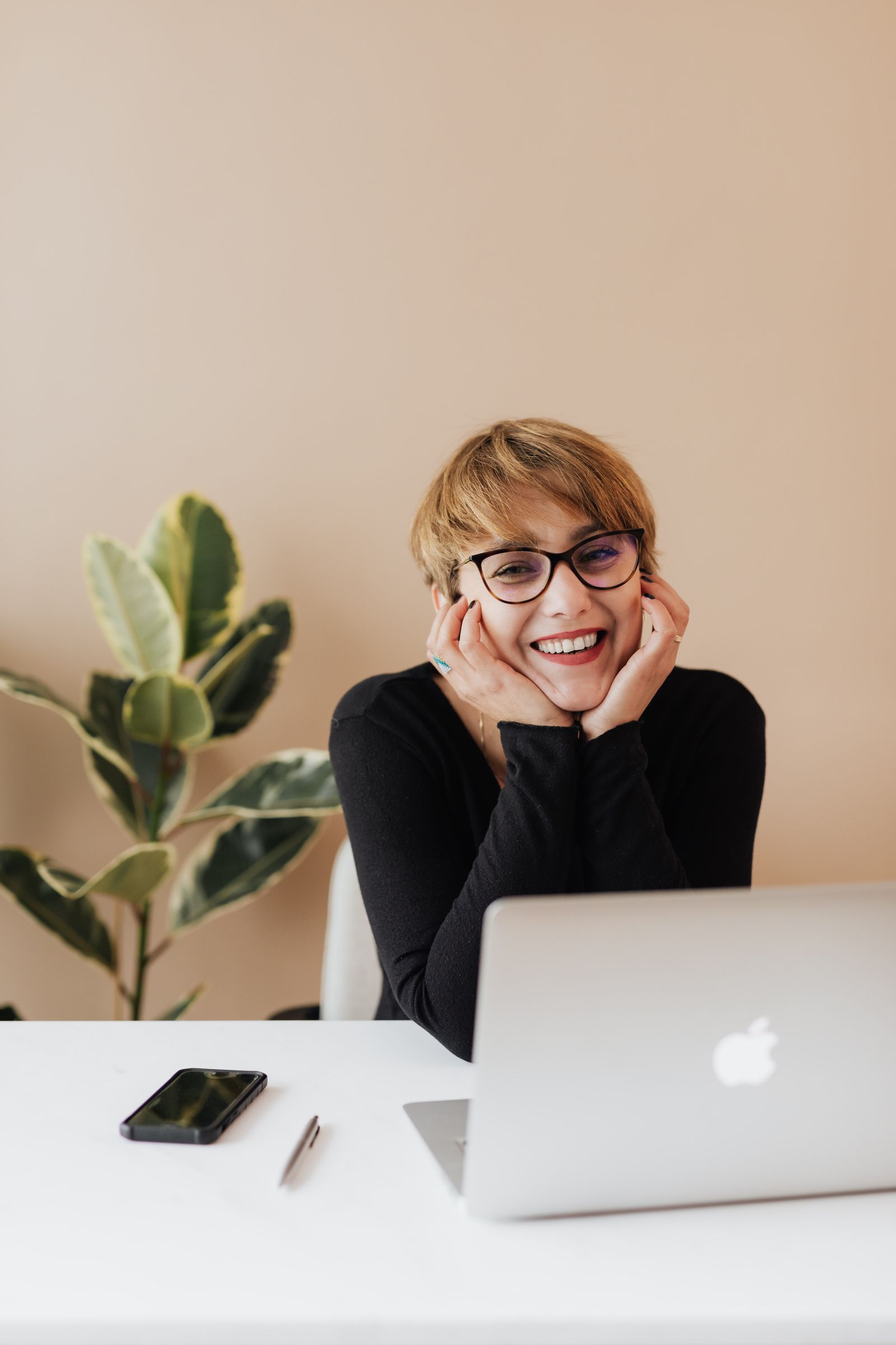 A person smiling while filing personal taxes on a laptop at home