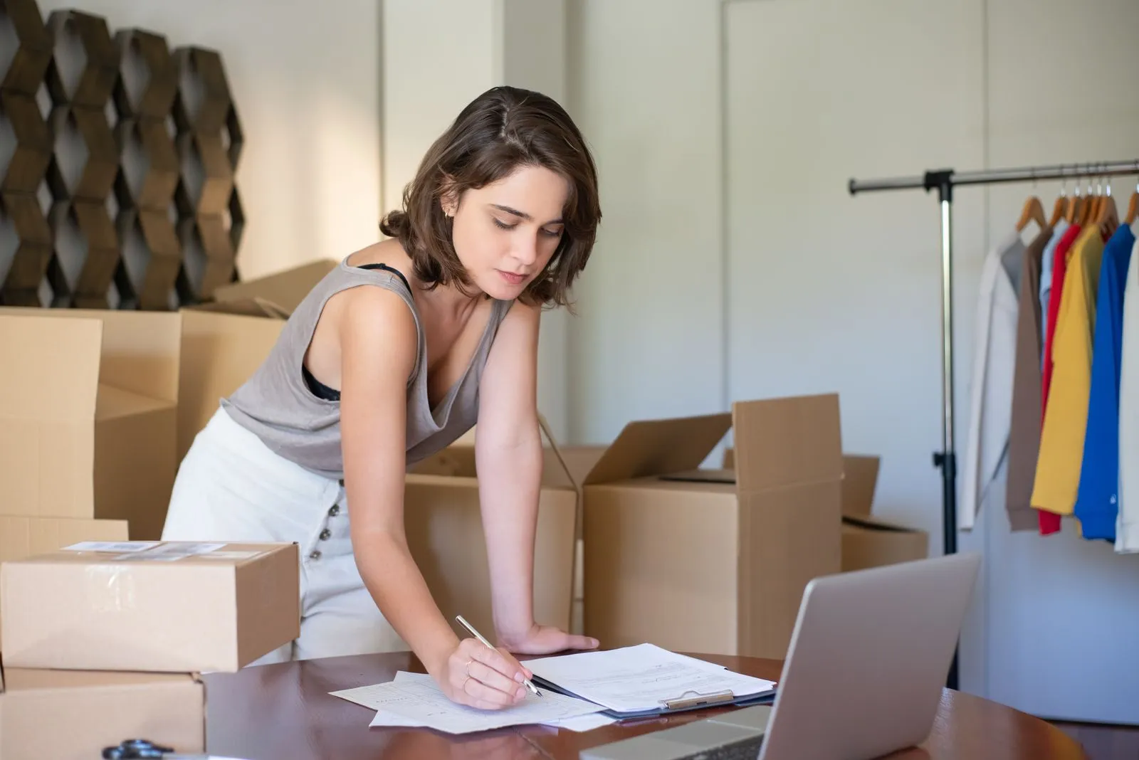 Small business owner reviewing paperwork and bookkeeping records at a desk