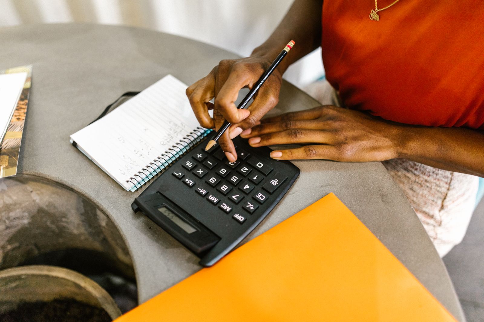 A person reviewing personal finances with a calculator during tax planning analysis