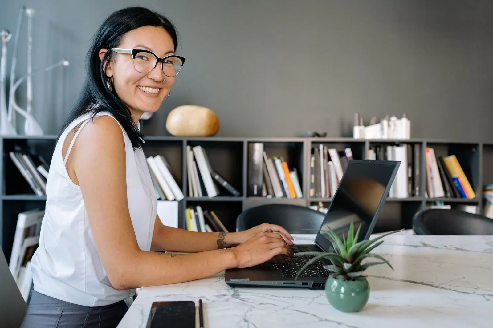 Small business owner smiling while working on a laptop at her desk