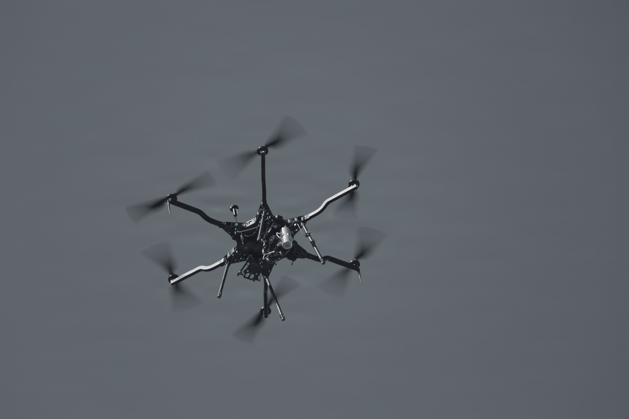 A hexacopter drone in flight against an open sky