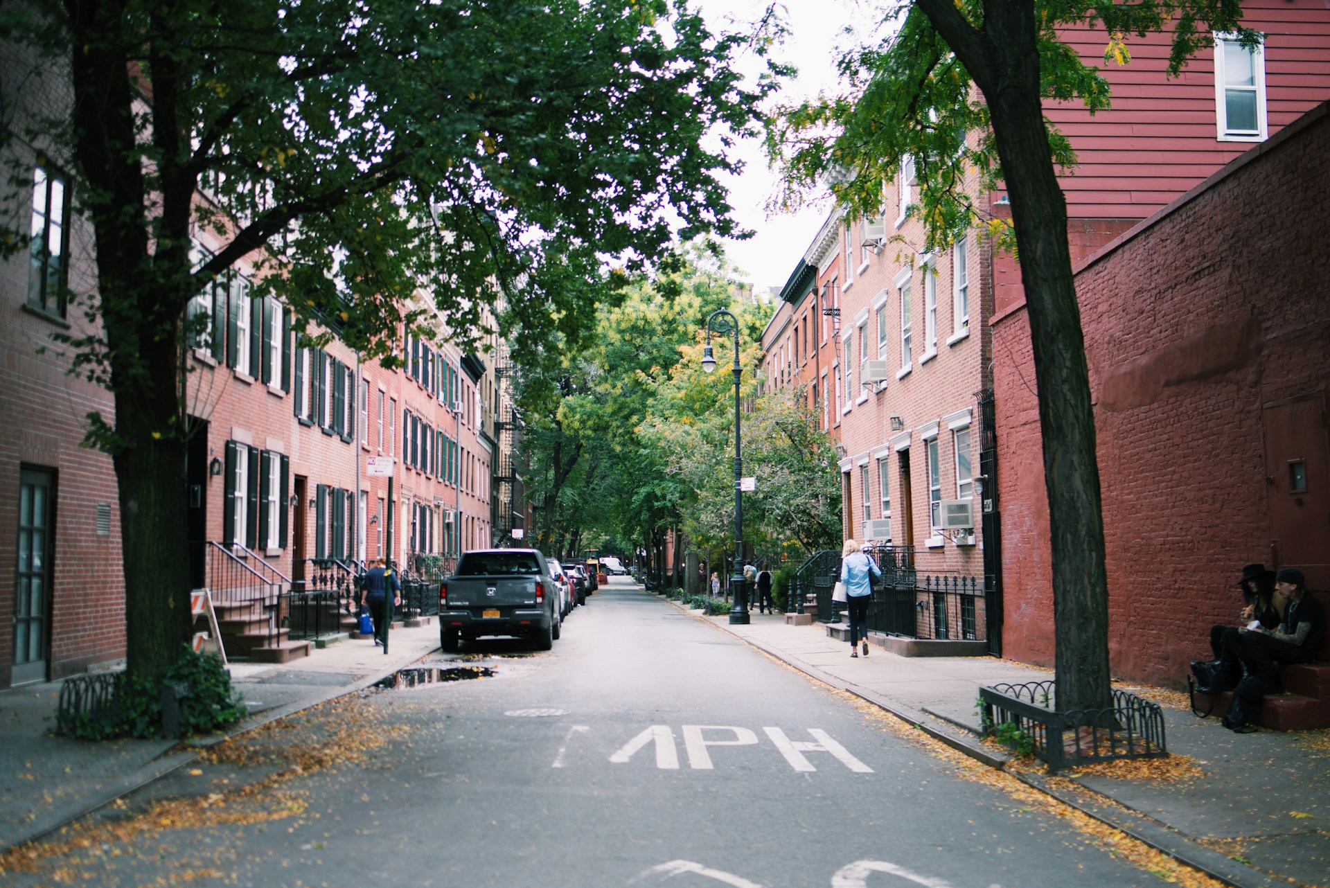 A tree-lined West Village street of brick townhouses