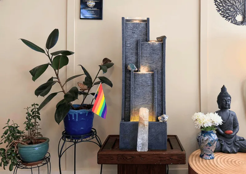 Slate water fountain with lit crystals, plants, and a Buddha statue in the studio