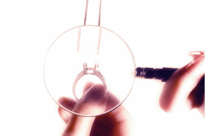 Diamond ring inspected through a magnifying glass