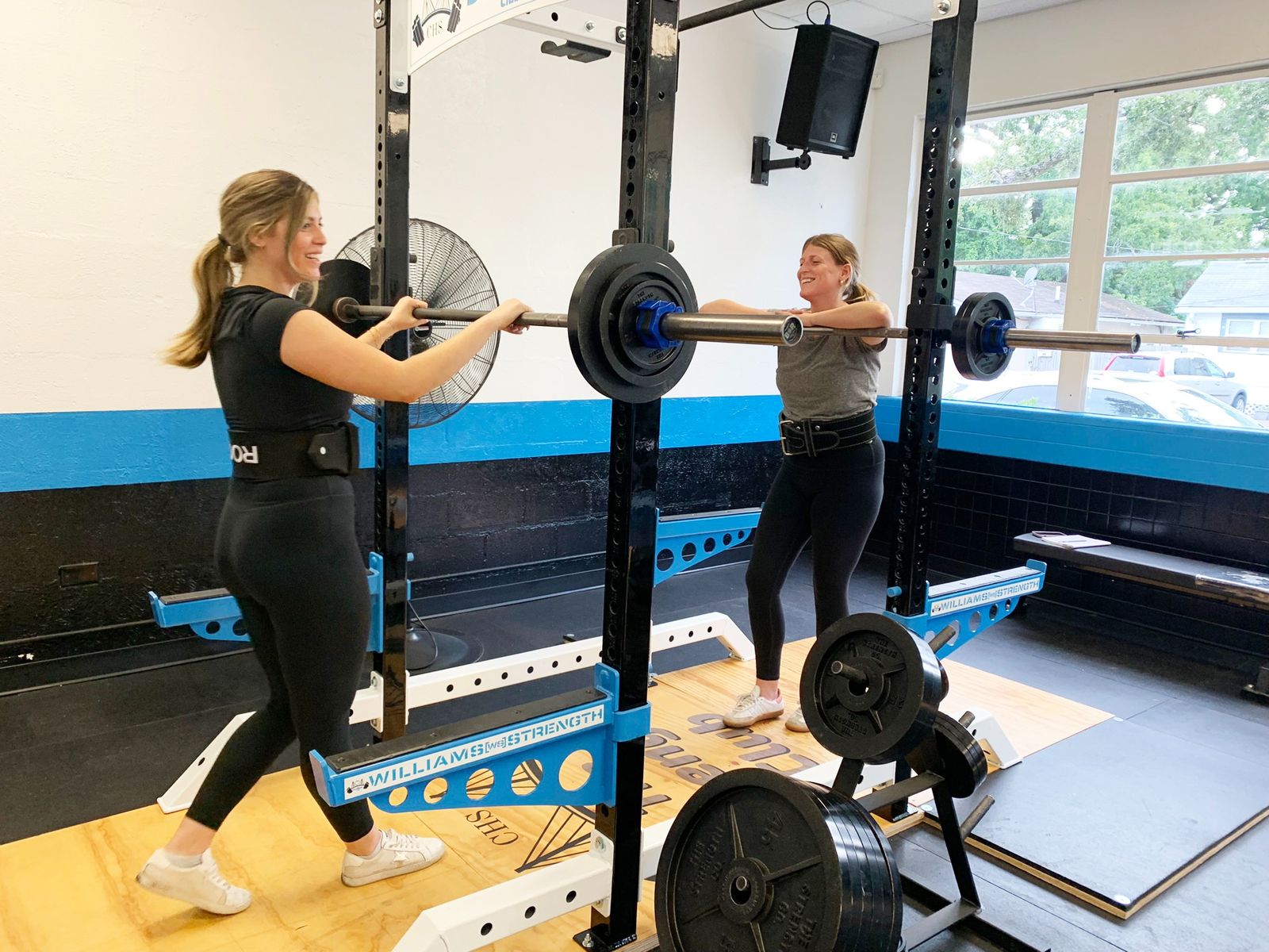 Members squatting in the racks at The Strength Club, a 24-hour strength training gym in Avondale, Charleston