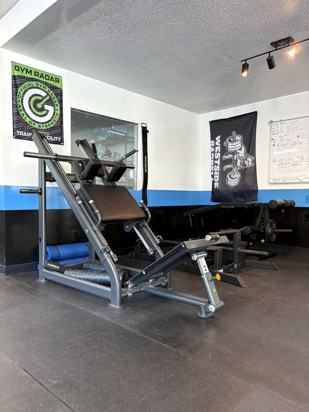 Hack squat and accessory machines on the floor at The Strength Club in Avondale, Charleston