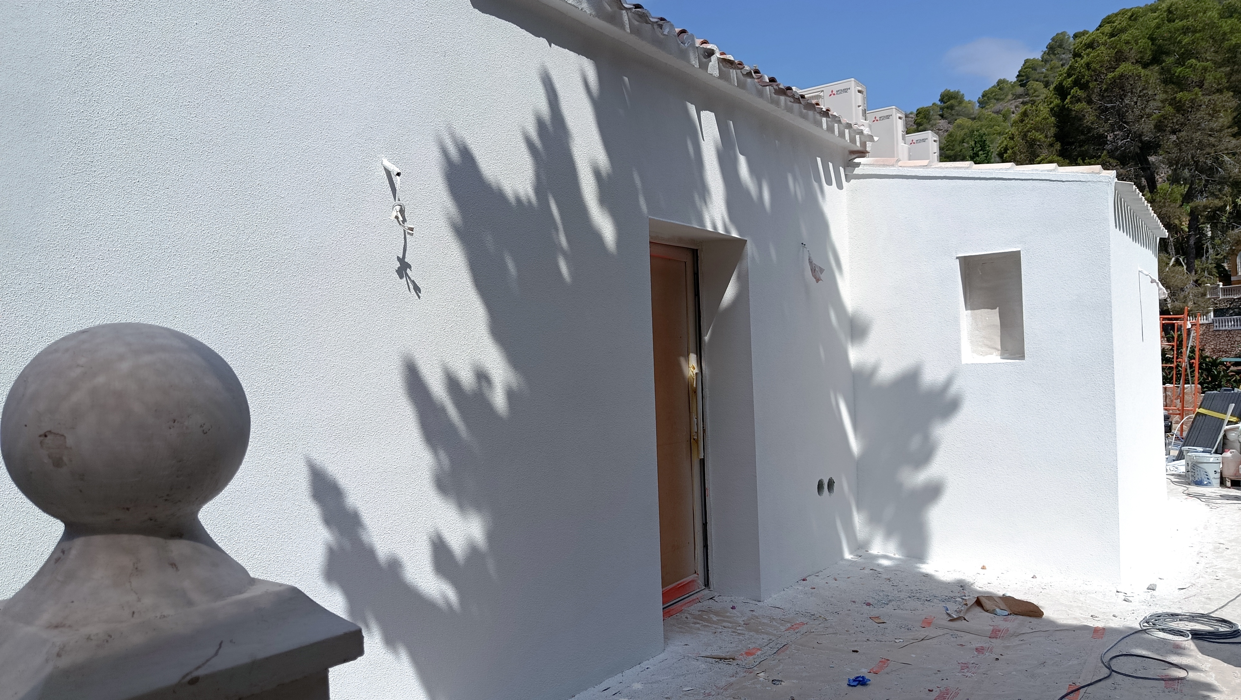 Fachada en Valencia con zonas revestidas y andamios durante la colocación del aislamiento exterior