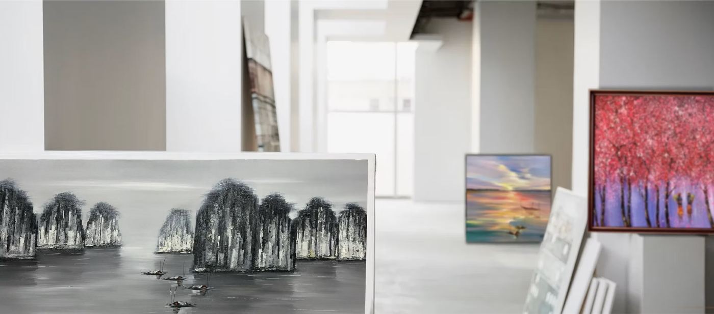 Inside the gallery showroom, canvases leaning and hung along the walls