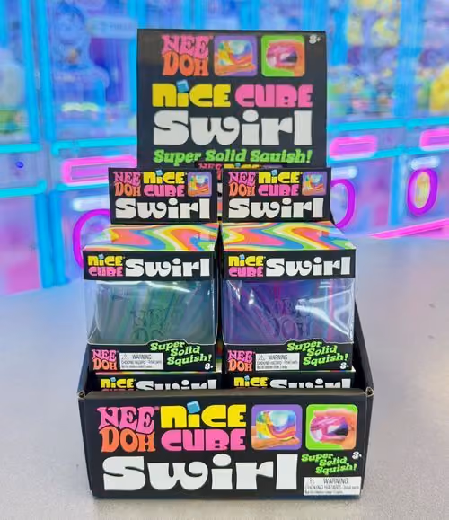 NeeDoh Nice Cube Swirl squishies stacked in front of the claw machines