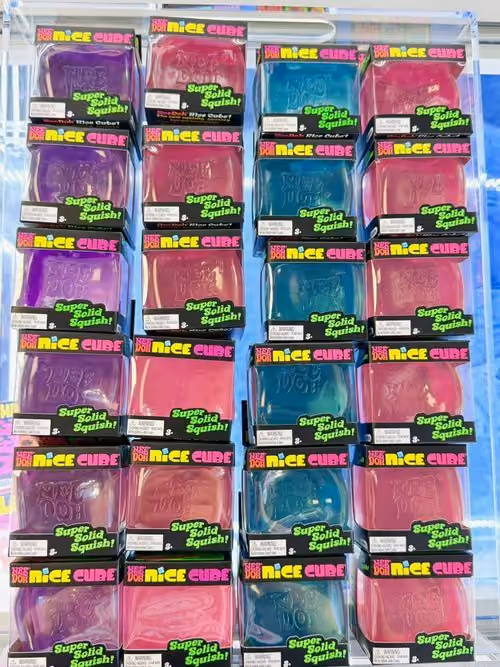 Rows of NeeDoh Nice Cube squishies in purple, pink and teal