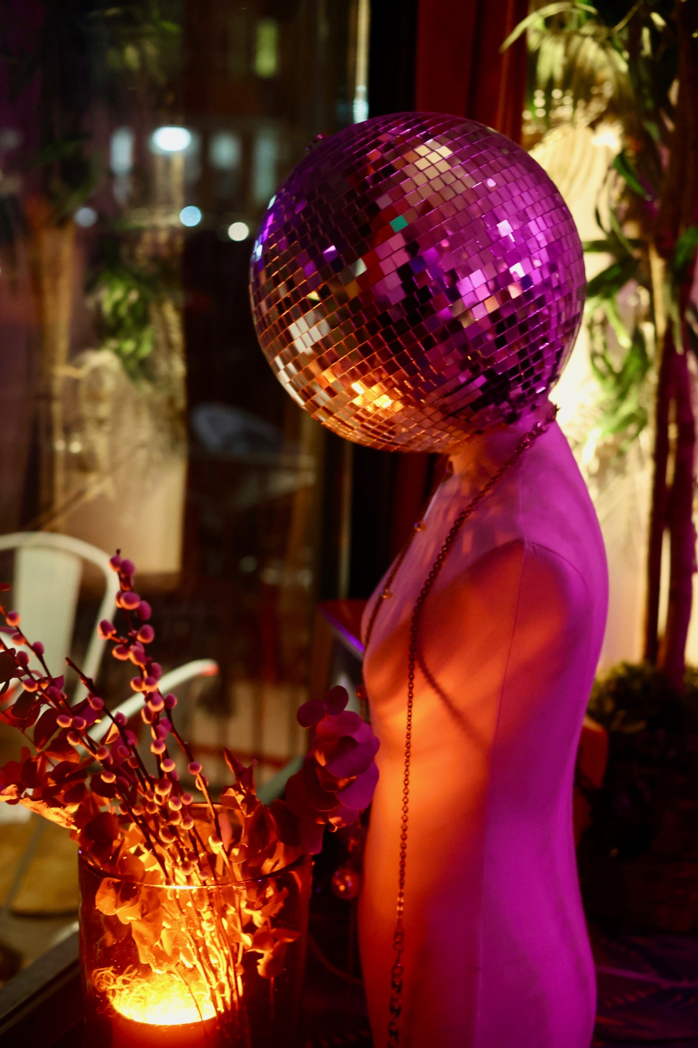 Disco-ball mannequin illuminated in purple and amber at Banshee House