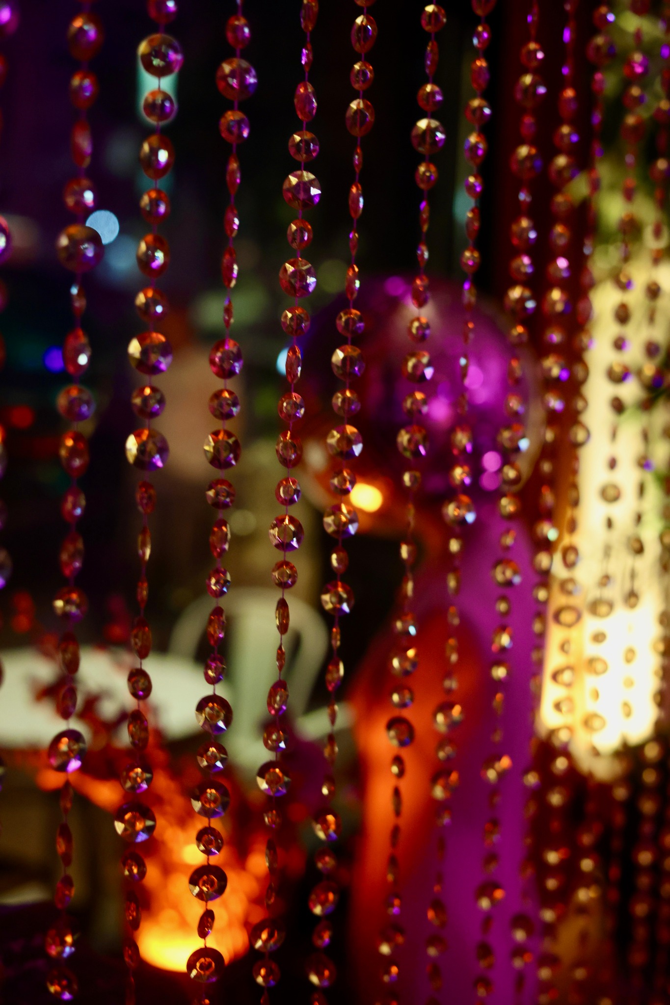 Beaded curtain catching purple and golden light