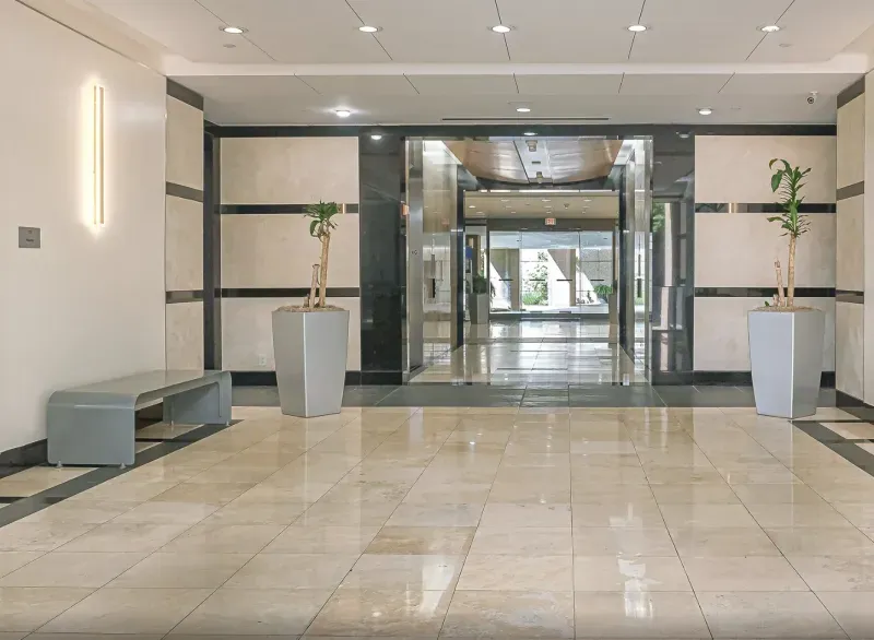 Marble corridor entrance with planters and bench