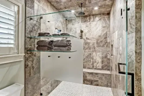 Marble bathroom shower with glass shelving