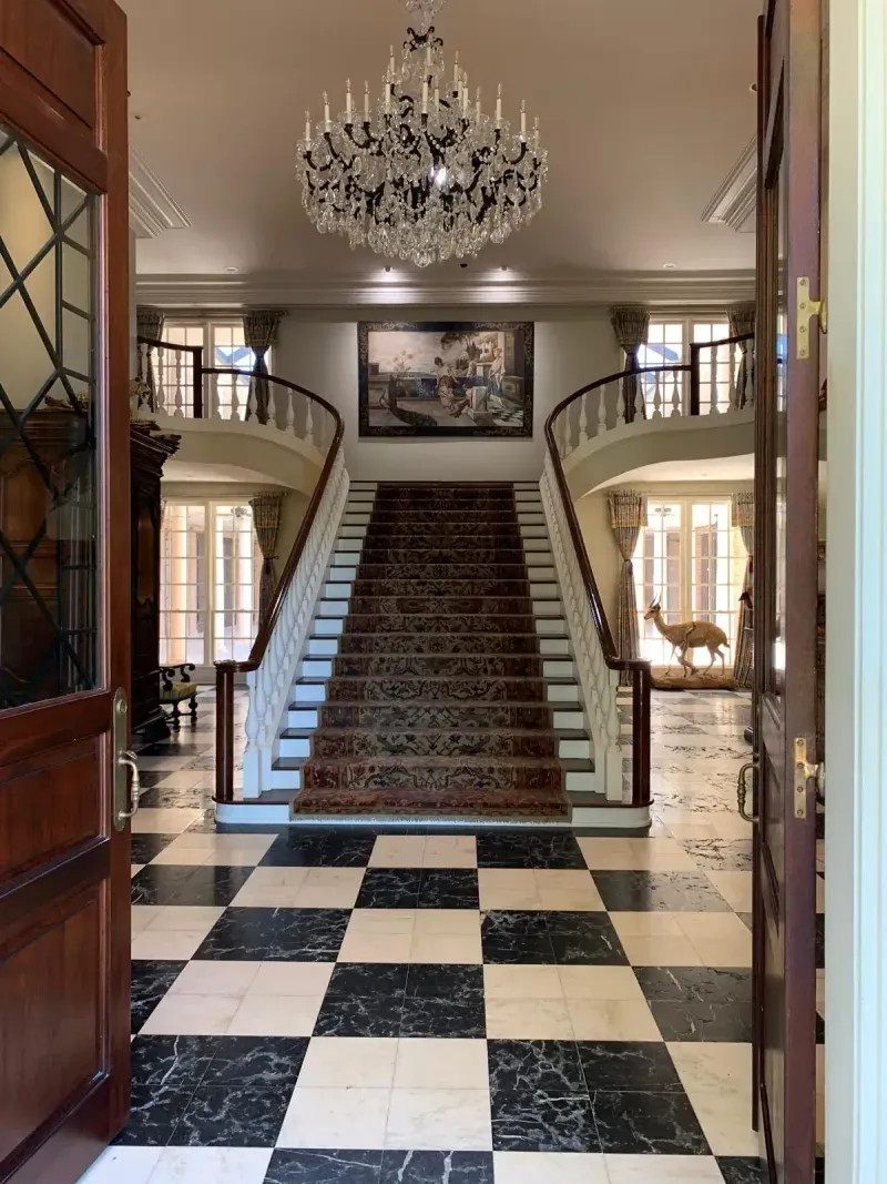 Grand foyer staircase with black and white checkerboard floor