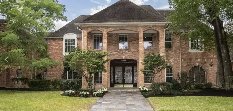 Brick custom estate exterior with iron and glass entry