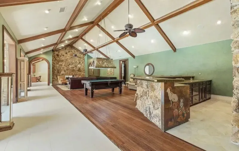 Finished game room with pool table and stone bar