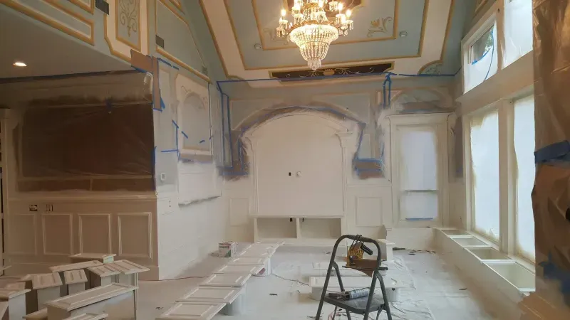 Formal room mid-restoration with ornate ceiling detail