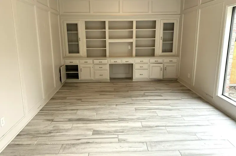 Built-in cabinetry and shelving with wood-look tile flooring