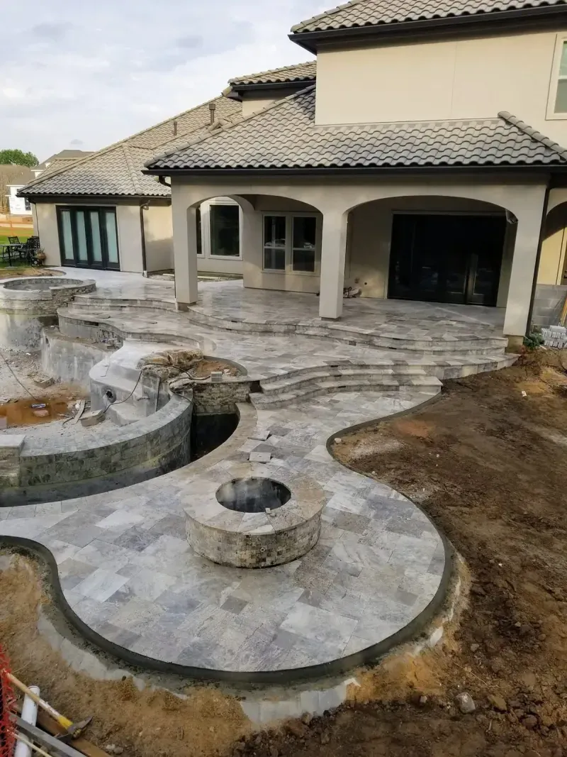 Curved stone patio and pool deck under construction
