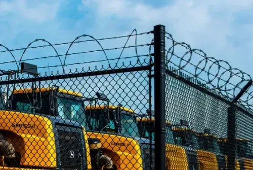 Perimeter security fencing with barbed wire around equipment yard