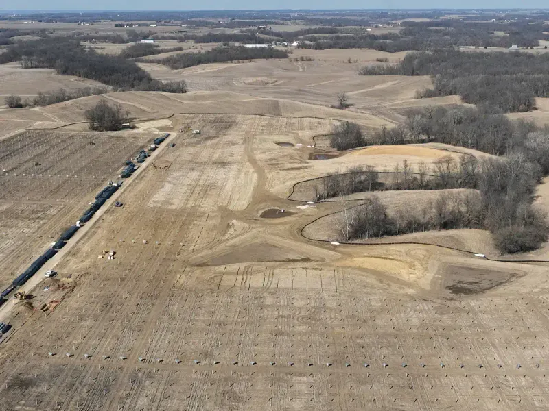 Aerial view of construction staging area with drainage pond