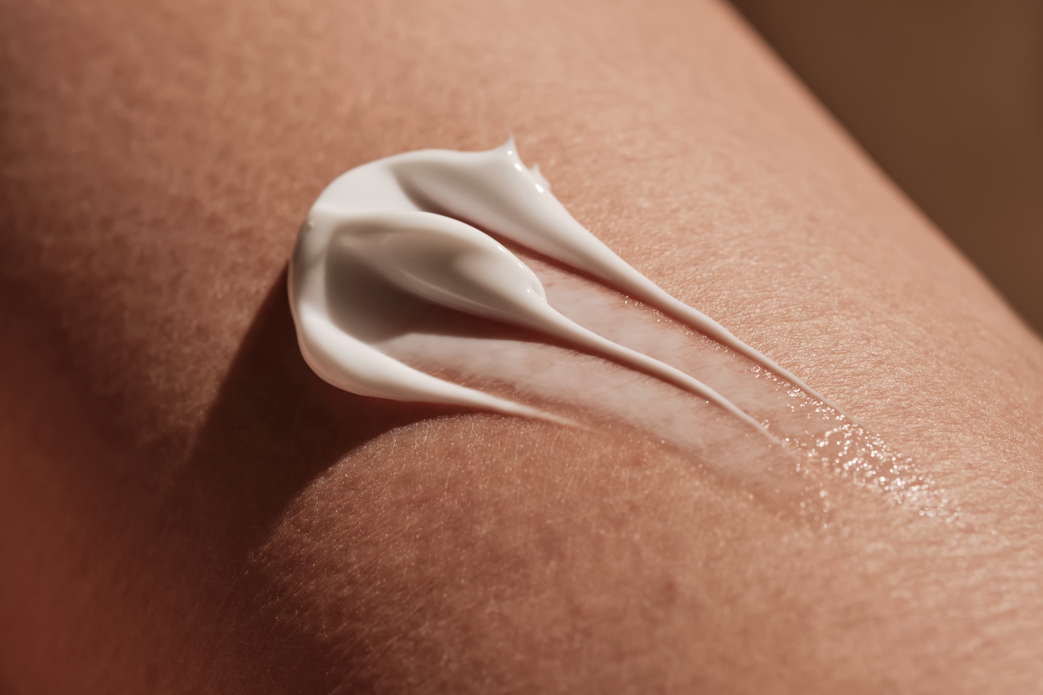 Close-up of white moisturizer smoothed across skin