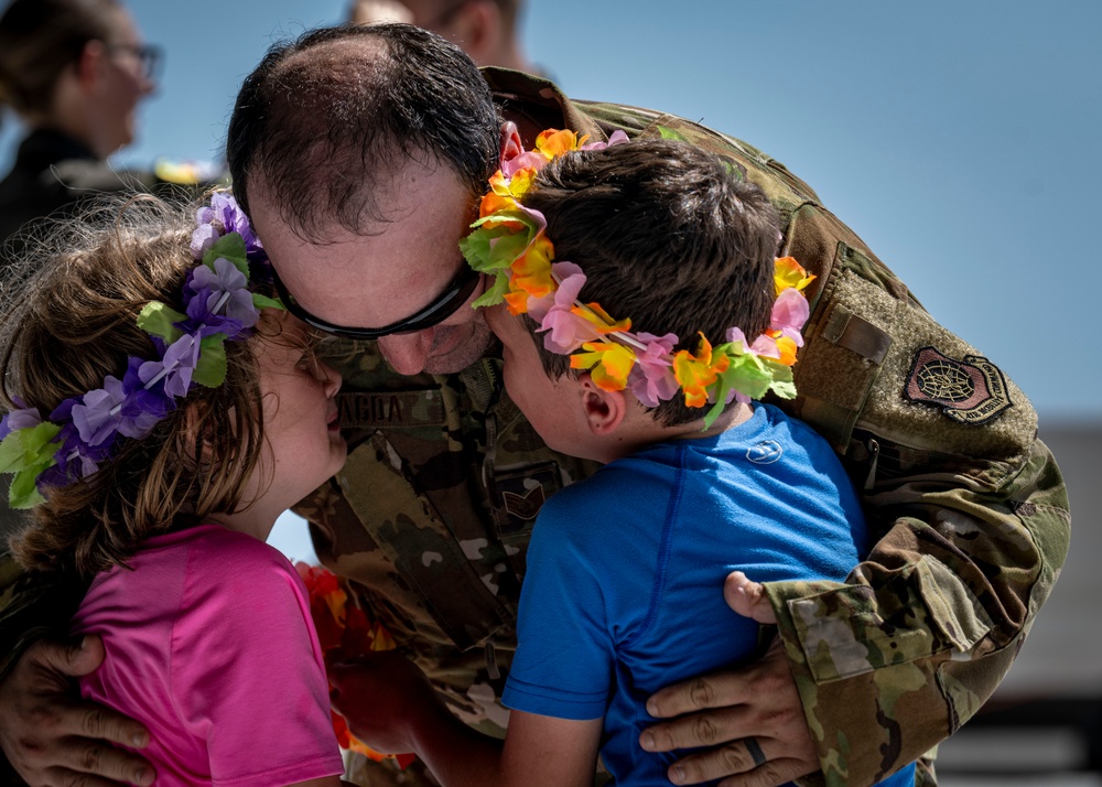 An airman embraces his two children at a military homecoming