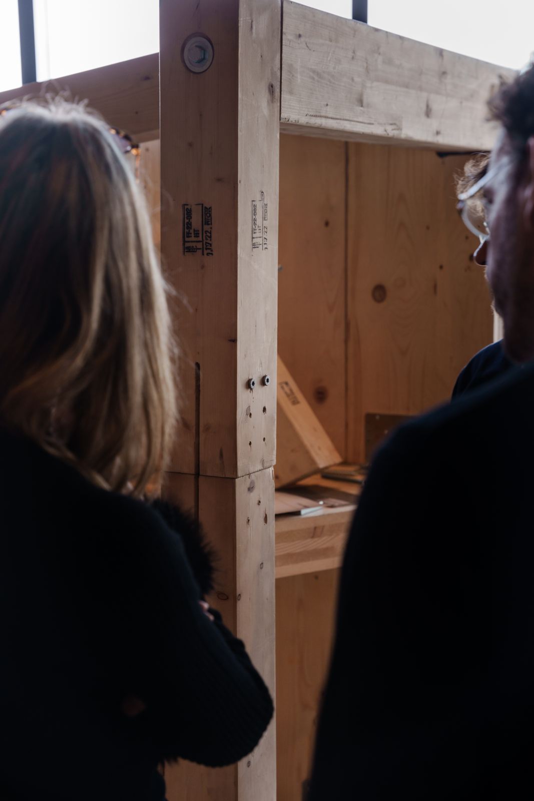 Detalle de la unión entre columna y viga de GLT en la maqueta, con dos personas observando