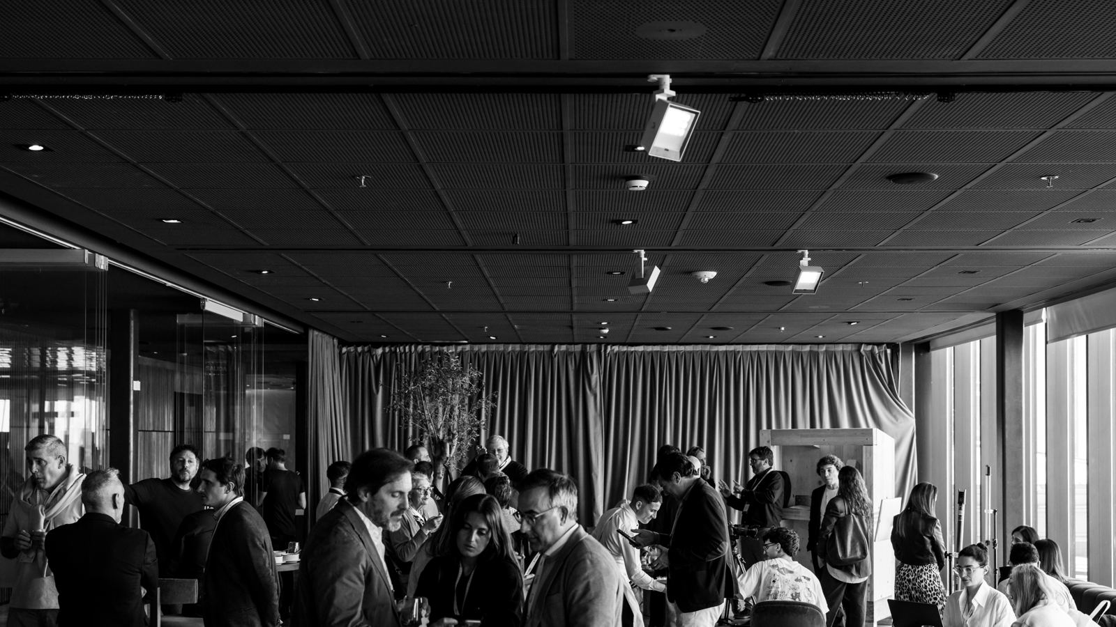 Vista general en blanco y negro de los asistentes en el área de exposición