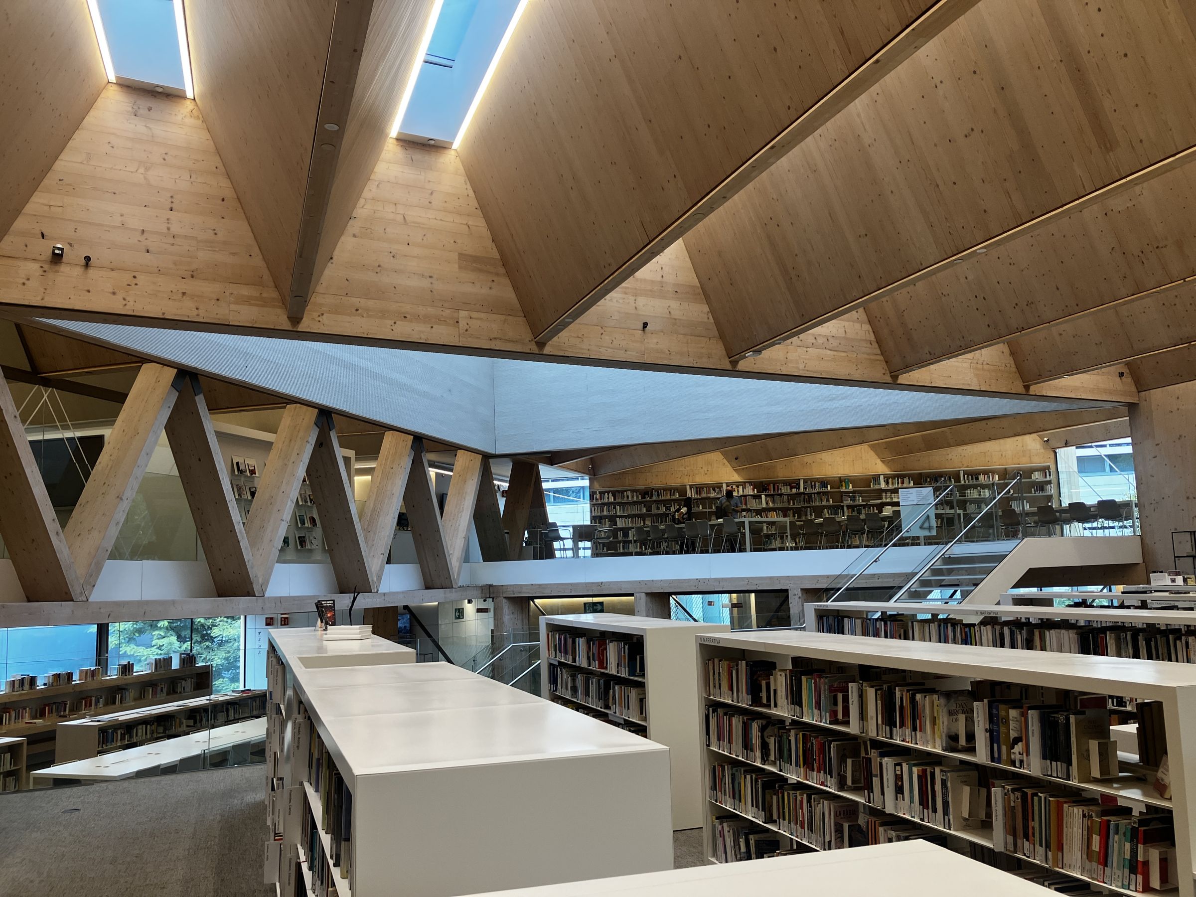 Cubierta plegada de madera con lucernarios y cerchas de madera laminada sobre la planta de narrativa de la biblioteca Gabriel García Márquez
