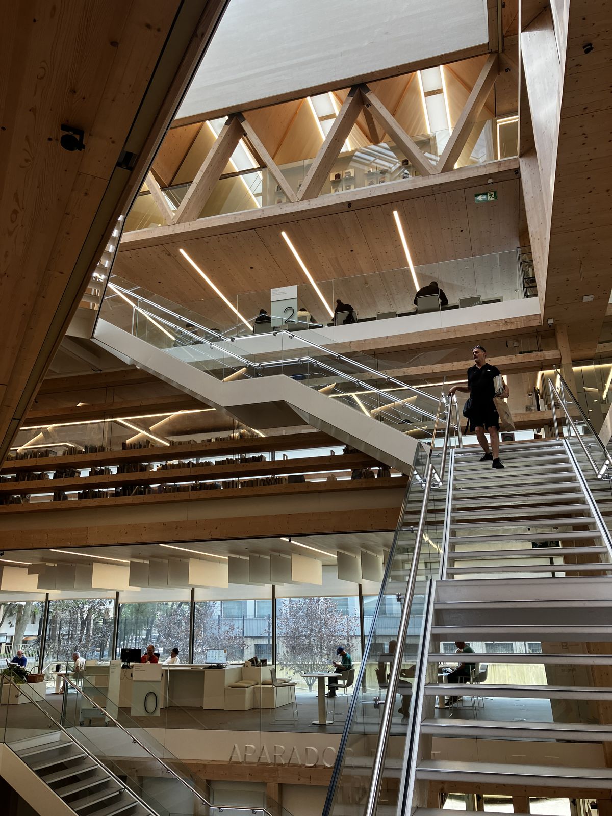 Atrio central de la biblioteca con escaleras, cerchas y forjados de madera