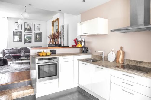 The white kitchen and worktops, a few steps below the lounge