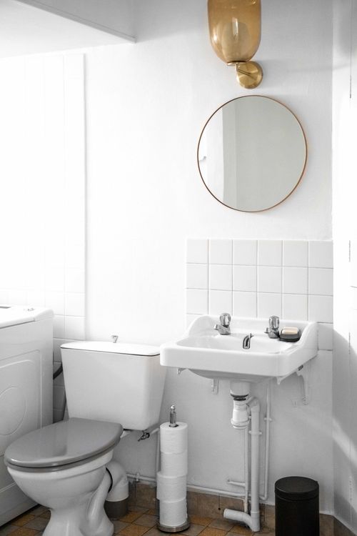The hand basin and round mirror in the toilet