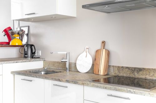 The kitchen sink and worktop with white cabinets