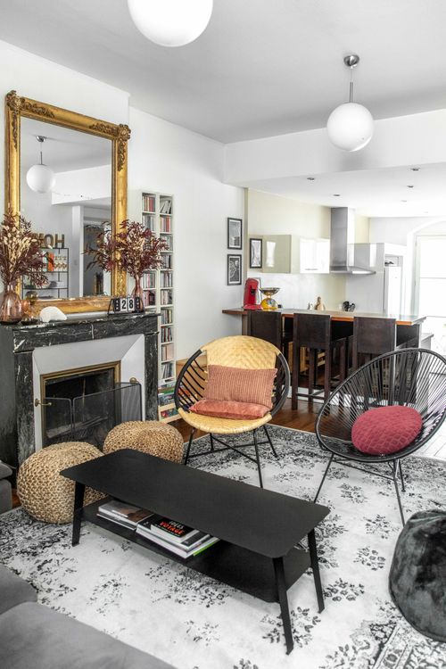 The lounge with its fireplace and gilt mirror, opening onto the kitchen
