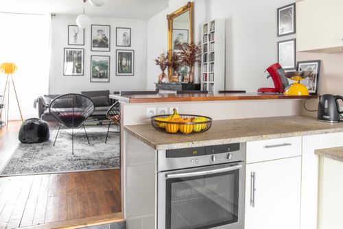 The kitchen opening onto the lounge, with a built-in oven beneath the worktop