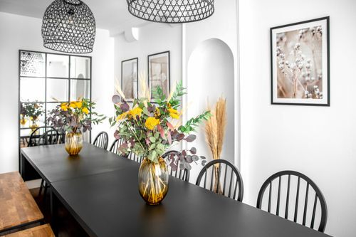 The long black dining table decorated with bouquets