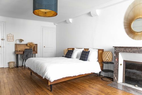 The first large bedroom with a double bed, desk and old fireplace