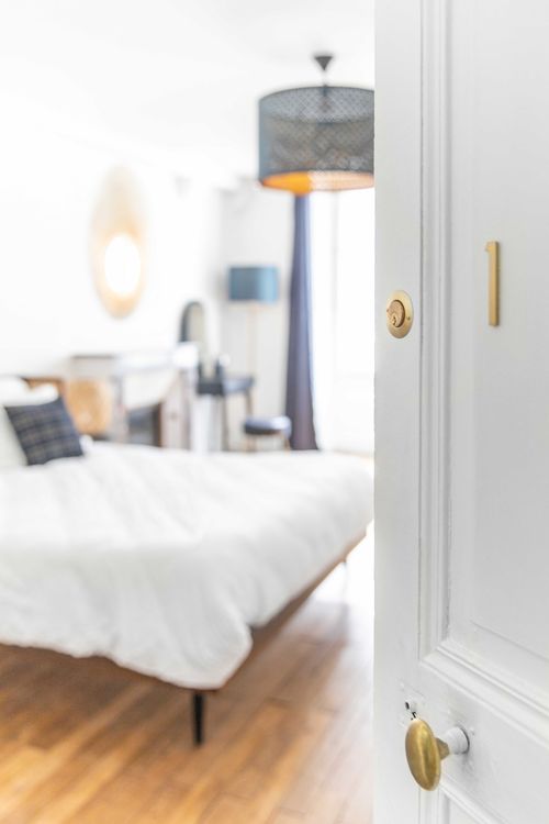 The first large bedroom seen through its half-open door