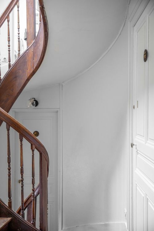 The curved handrail of the old wooden staircase
