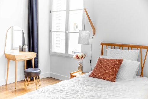 The double bed and dressing table near the window in the second bedroom