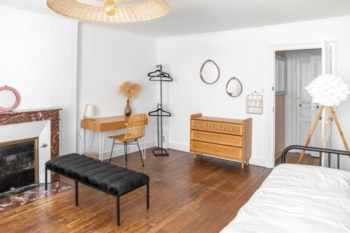 The desk, chest of drawers and fireplace in the second large bedroom