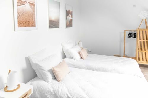 Two single beds side by side in the bedroom with pastel illustrations