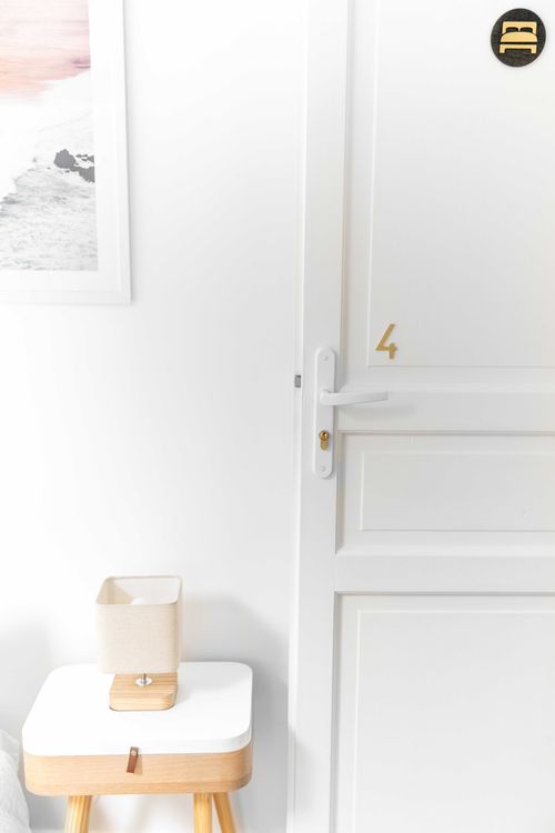 The bedside table and small lamp near the bedroom door